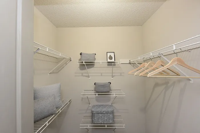 Spacious and organized walk-in closet with wire shelving, hangers, and stylish storage baskets.