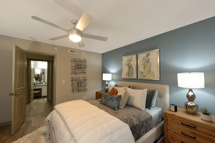 Cozy bedroom with modern decor, featuring a plush bed, elegant artwork, and soft lighting for a relaxing atmosphere.