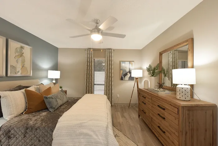 Inviting bedroom with modern decor, featuring a plush bed, elegant wooden dresser, and warm ambient lighting.