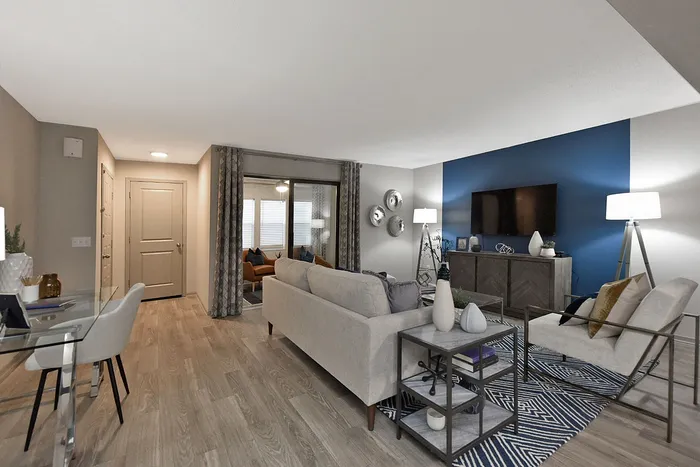 Modern living room with elegant decor, featuring a cozy seating area, stylish accent wall, and chic flooring.