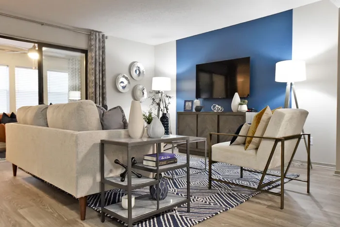 Modern living room with stylish furniture, elegant lighting, and a vibrant blue accent wall.