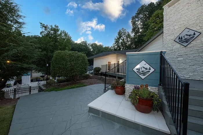 Charming apartment entrance with elegant stonework, lush greenery, and serene surroundings, perfect for nature lovers.