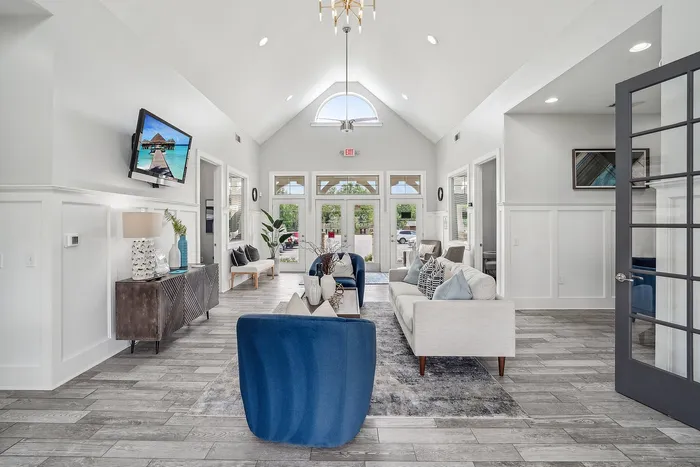 Elegant and bright communal living area with high vaulted ceilings, stylish decor, and modern furnishings, creating an inviting atmosphere for relaxation and social gatherings.