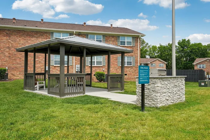 Charming outdoor gazebo and modern grill area surrounded by lush green lawns, perfect for gatherings and relaxation.