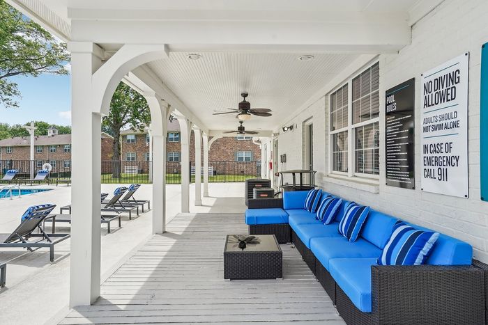 Inviting poolside patio with modern blue cushioned seating, stylish accents, and a relaxing resort atmosphere.