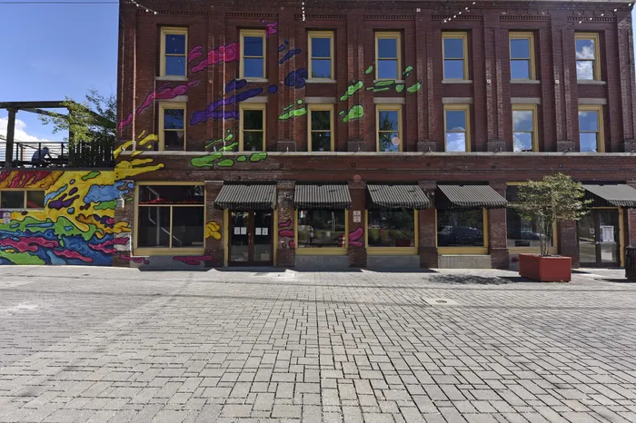 Vibrant urban building with colorful graffiti art, offering a creative and lively atmosphere in a trendy district.