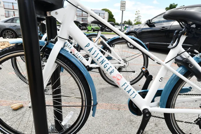 Modern, sleek white bicycles with blue accents parked neatly in a vibrant apartment community parking area offering convenience and style.