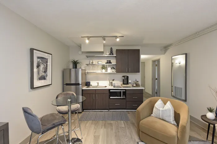 Chic apartment kitchenette with modern cabinetry, sleek appliances, and cozy seating area for a stylish living experience.