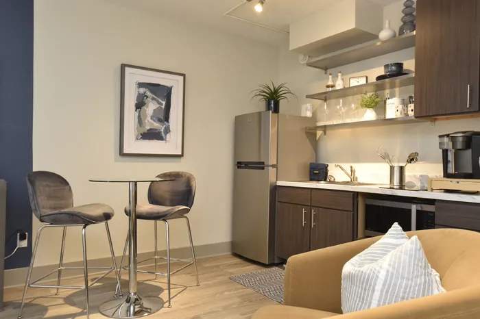 Cozy modern kitchen with sleek cabinetry, open shelving, and stylish dining nook for two.