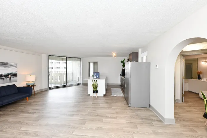 Bright and spacious open-plan living area with modern kitchen and large windows, perfect for contemporary living.