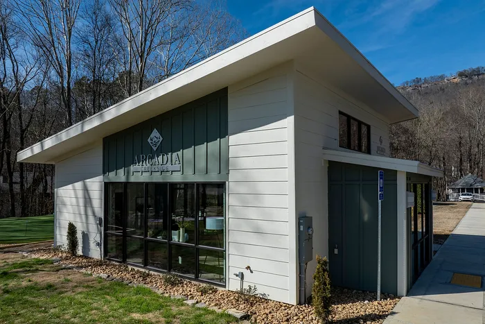 Charming modern building with a stylish angled roof, featuring large glass windows and surrounded by nature for a peaceful setting.