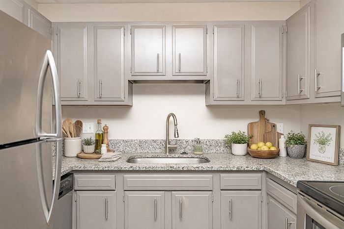 Chic modern kitchen with sleek gray cabinets, stainless steel appliances, and stylish granite countertops.