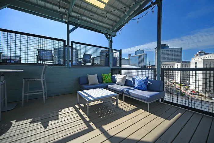 Chic rooftop patio with stylish seating, offering a stunning city skyline view and perfect for entertaining.