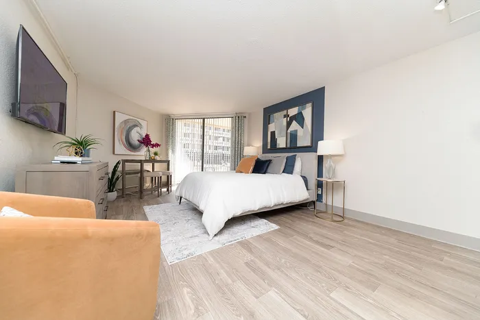 Bright and spacious bedroom featuring modern decor, large bed, and elegant wooden flooring, perfect for a cozy retreat.