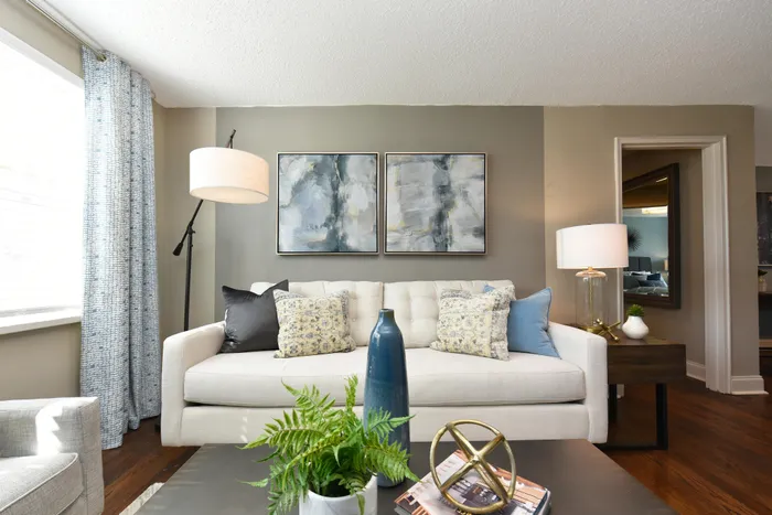 Bright and inviting living room with elegant decor, showcasing a cozy sofa adorned with patterned cushions, stylish abstract art, and abundant natural light.