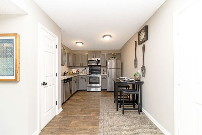 Modern kitchen with sleek stainless steel appliances, stylish gray cabinets, and a cozy breakfast nook, offering a blend of elegance and functionality.