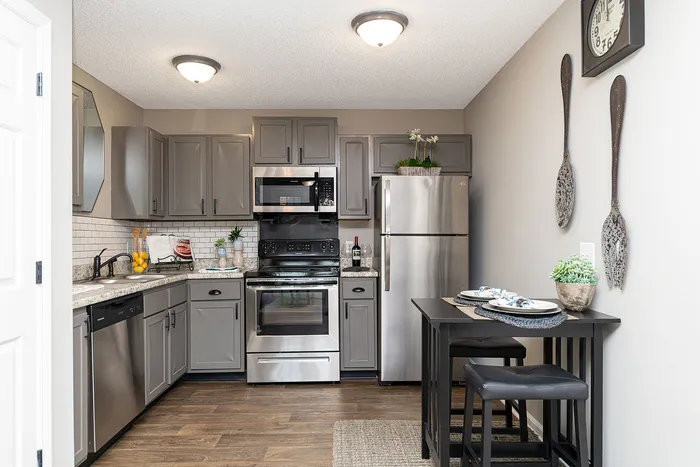 Modern kitchen with sleek gray cabinetry, stainless steel appliances, and chic dining nook.