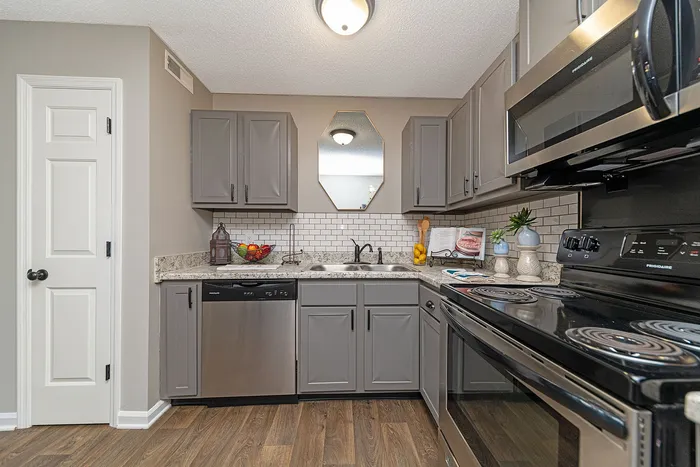 Contemporary kitchen with sleek gray cabinetry, stainless steel appliances, and elegant tile backsplash, perfect for modern living.