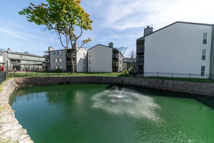 Charming apartment complex with a serene lake view, lush green surroundings, and modern architectural design.