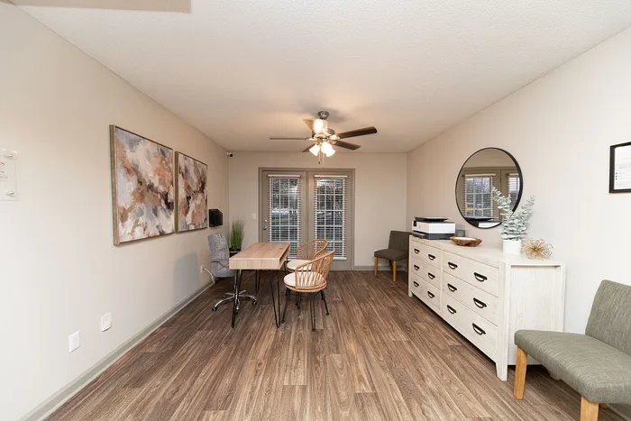 Inviting workspace with elegant wooden flooring, modern artwork, and ample natural light from French doors.