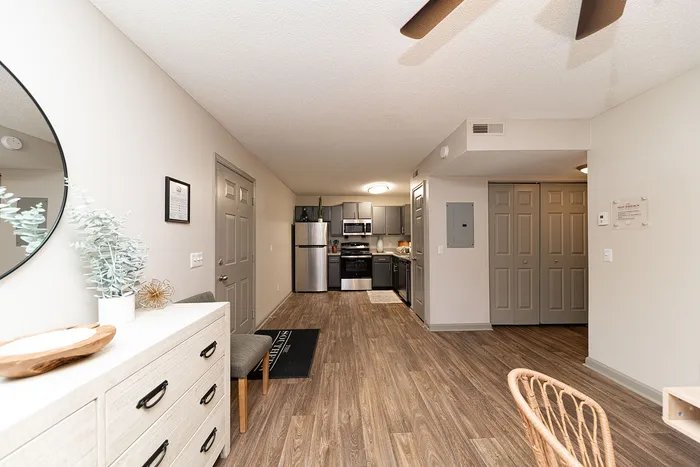 Modern open-concept kitchen and entryway with sleek cabinetry and stylish flooring, radiating warmth and sophistication.