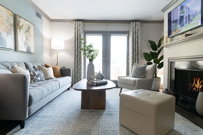 Elegant living room featuring a cozy gray sofa, modern artwork, and a warm fireplace, perfect for relaxing evenings.