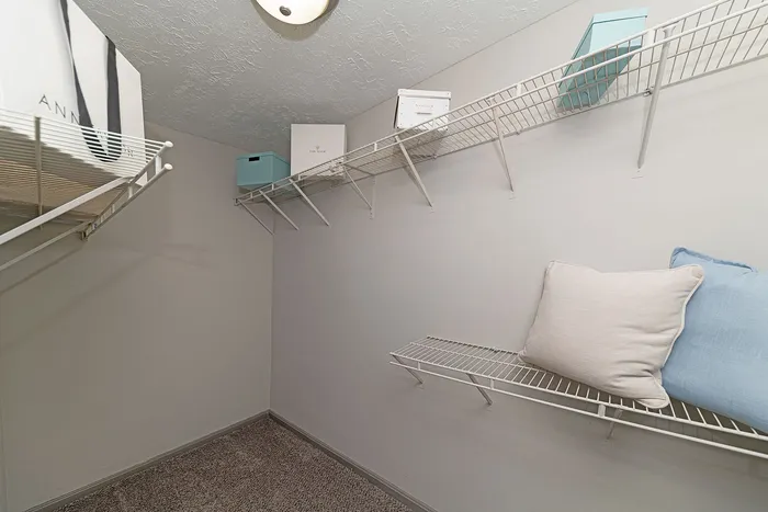 Spacious walk-in closet with ample shelving, perfect for organized storage in a modern apartment.