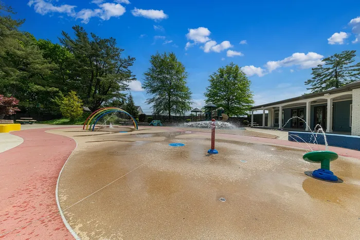 Inviting community splash pad with vibrant play features and lush greenery, perfect for family fun.
