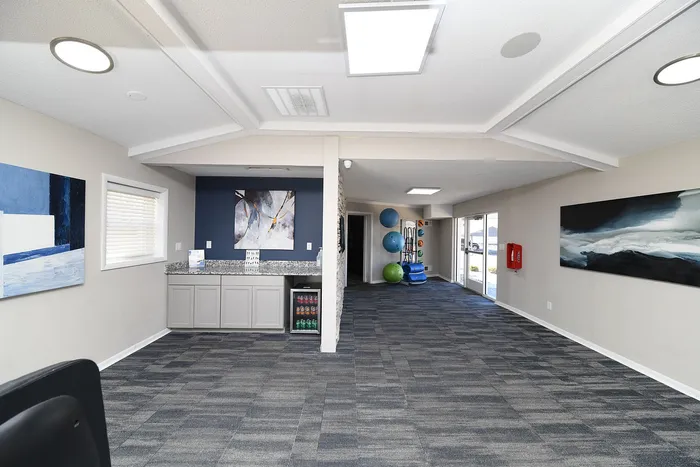 Modern community center with stylish seating area, vibrant wall art, and fitness equipment, perfect for a welcoming lifestyle.
