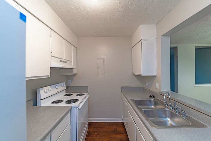 Cozy kitchen with modern white cabinetry, sleek countertops, and a classic electric stove, perfect for cooking enthusiasts.