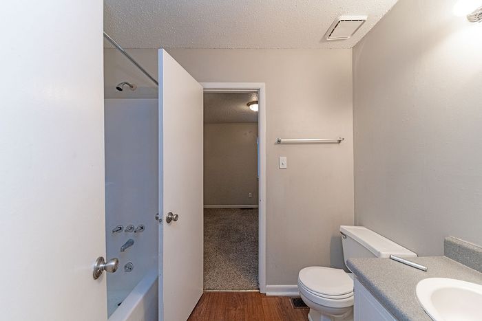 Bright modern bathroom featuring a sleek white bathtub, contemporary vanity, and inviting ambiance.