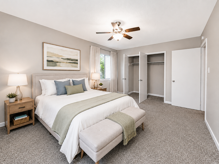 Inviting bedroom with a cozy king-sized bed, soothing decor, ample storage space, and natural light.