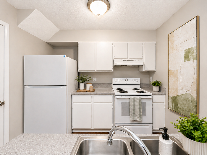 Charming kitchen with modern white cabinetry, cozy lighting, and a spacious countertop perfect for culinary creations.