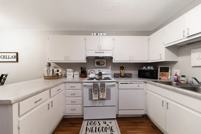 Inviting kitchen with charming decor, bright white cabinets, and a welcoming atmosphere, perfect for home cooking.
