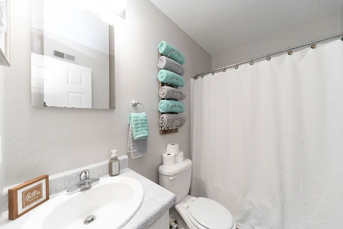 Charming bathroom with a sleek sink, stylish towel arrangement, and a fresh, inviting ambiance.
