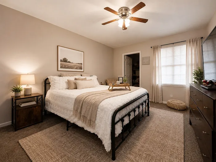 Cozy and inviting bedroom featuring a stylish metal bed frame, soft lighting, elegant decor, and a serene ambiance.