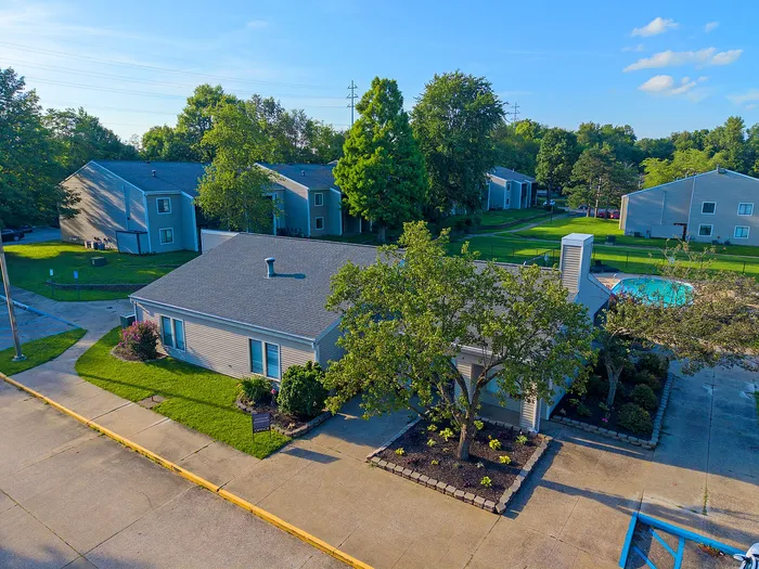 Charming apartment community showcasing lush greenery, a pristine swimming pool, and modern exterior design.