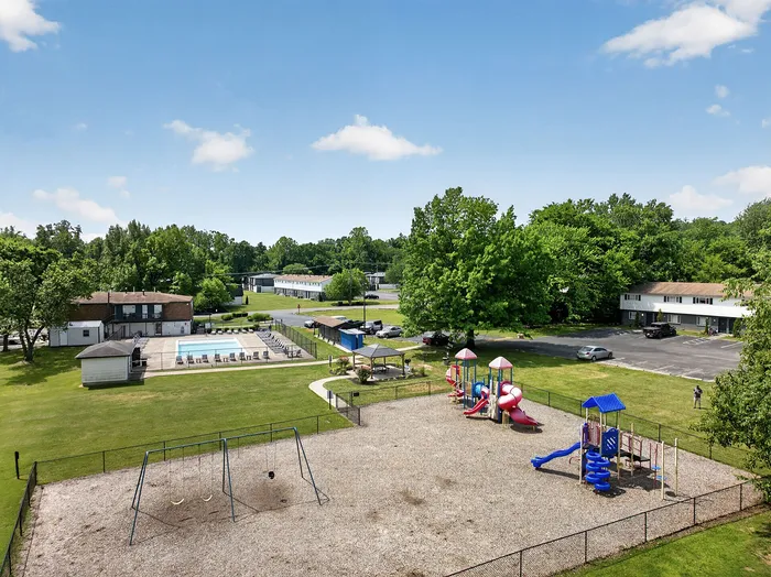 Inviting community view with a vibrant playground, refreshing outdoor pool, and lush green surroundings perfect for family living.