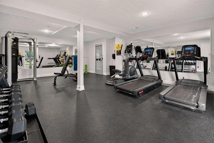 Modern fitness center with state-of-the-art treadmills, weight station, and ample space for workouts.