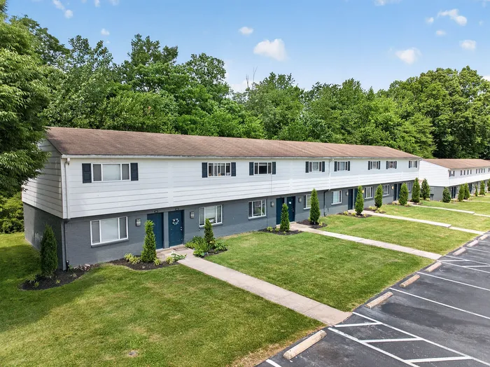 Charming row of townhouses with manicured lawns and lush green surroundings, offering idyllic suburban living.