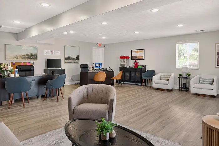 Contemporary office space with elegant seating, stylish desks, modern decor, and natural lighting.