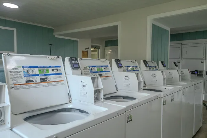 Modern laundry facility with multiple top-loading washing machines, providing convenience and efficiency for residents.