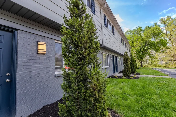 Charming apartment exterior with well-maintained greenery, showcasing modern design and inviting curb appeal.