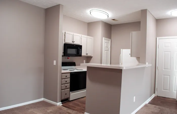 Modern kitchen with sleek cabinetry, integrated appliances, and an inviting breakfast bar in a cozy apartment setting.