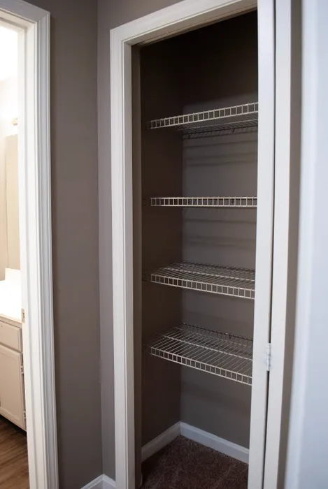 Spacious apartment closet with multiple wire shelves, perfect for organizing and maximizing storage.