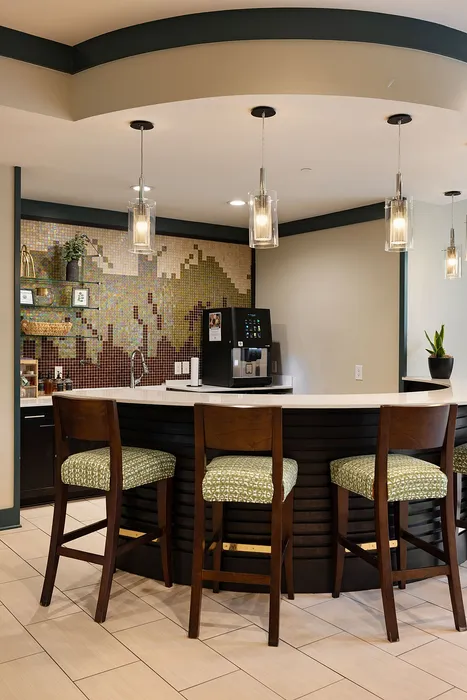Inviting kitchen corner with chic pendant lighting, mosaic tile backsplash, and elegant bar seating.