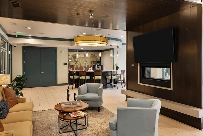 Elegant apartment lounge with a cozy seating area, stylish decor, and a modern bar setup, perfect for relaxing and entertaining.