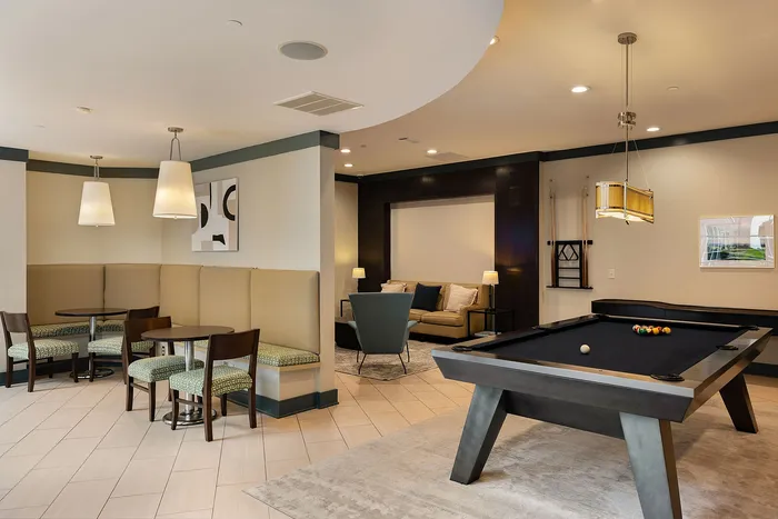 Luxurious communal area featuring elegant seating, ambient lighting, and a stylish billiards table, perfect for relaxation and entertainment.