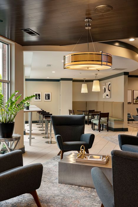 Chic and modern communal lounge area featuring elegant seating, stylish lighting, and a cozy dining nook, perfect for socializing and relaxation.