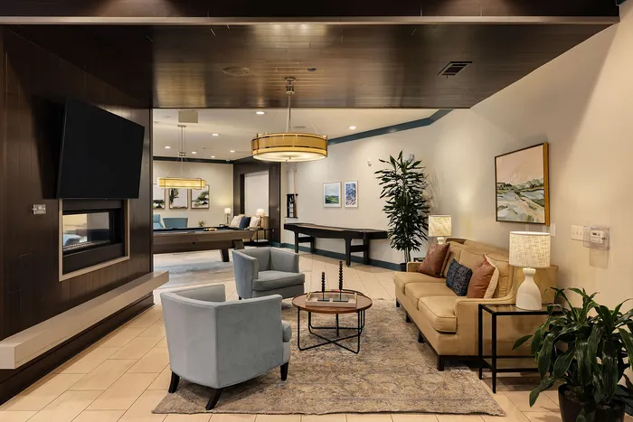 Elegant and cozy lounge area with plush seating, a modern fireplace, stylish artwork, and a sleek entertainment setup, perfect for relaxation and gatherings.